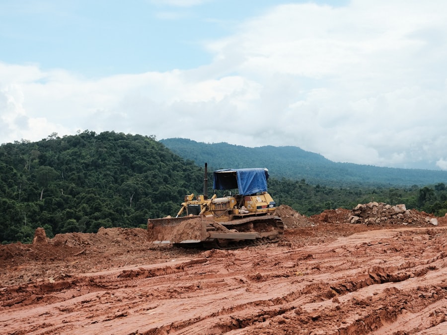 A bulldozer shaping and levelling a dirt construction site into a building pad.