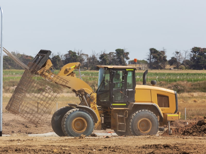 A bulldozer spreading fill dirt across a cleared building site.
